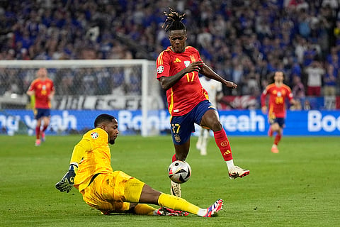 Mike Maignan tackles Spain's Nico Williams